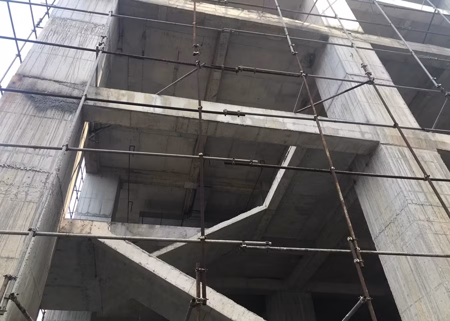 Hệ thống giàn giáo sắt bên trong công trường để căng lưới, đảm bảo an toàn trong quá trình thi công, tránh cho vật liệu xây dựng rơi ra phía ngoài hiện nay đã hoen rỉ.