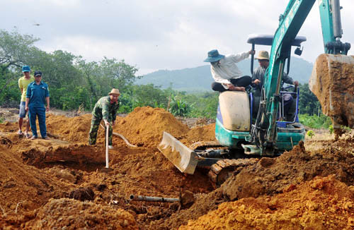 Máy xúc và sức người được huy động để tìm kiếm hài cốt liệt sĩ. Ảnh: Đăng Tùng/Đồng Nai