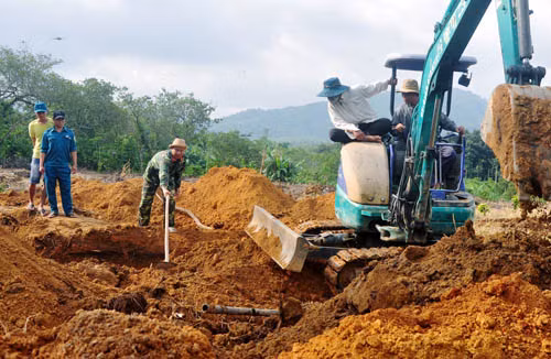 Máy xúc và sức người được huy động để tìm kiếm hài cốt liệt sĩ. Ảnh: Đăng Tùng/Đồng Nai