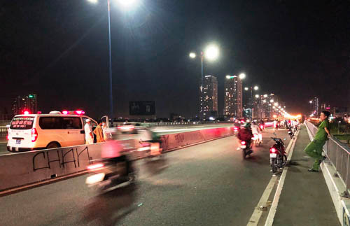 Công an phường 22, quận Bình Thạnh bảo vệ hiện trường trên cầu Sài Gòn, nơi nam thanh niên bỏ lại chiếc xe máy nhày sông mất tích.