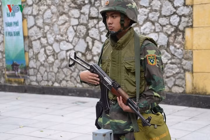 Một quân nhân đứng gác bên xe thiết giáp BTR-60 triển khai trên đường phố Hà Nội để bảo vệ Thượng đỉnh Mỹ-Triều và lãnh đạo Triều Tiên thăm hữu nghị chính thức Việt Nam.