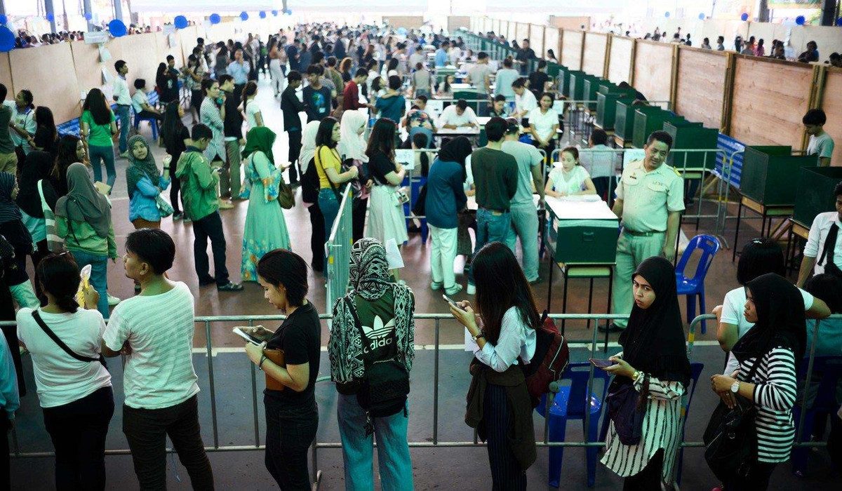 Người dân xếp hàng tại một địa điểm bầu cử khác ở thủ đô Bangkok. Cảnh sát Thái Lan huy động toàn bộ lực lượng để bảo đảm an ninh và phân luồng giao thông phục vụ cuộc bỏ phiếu sớm. Ảnh: AFP.