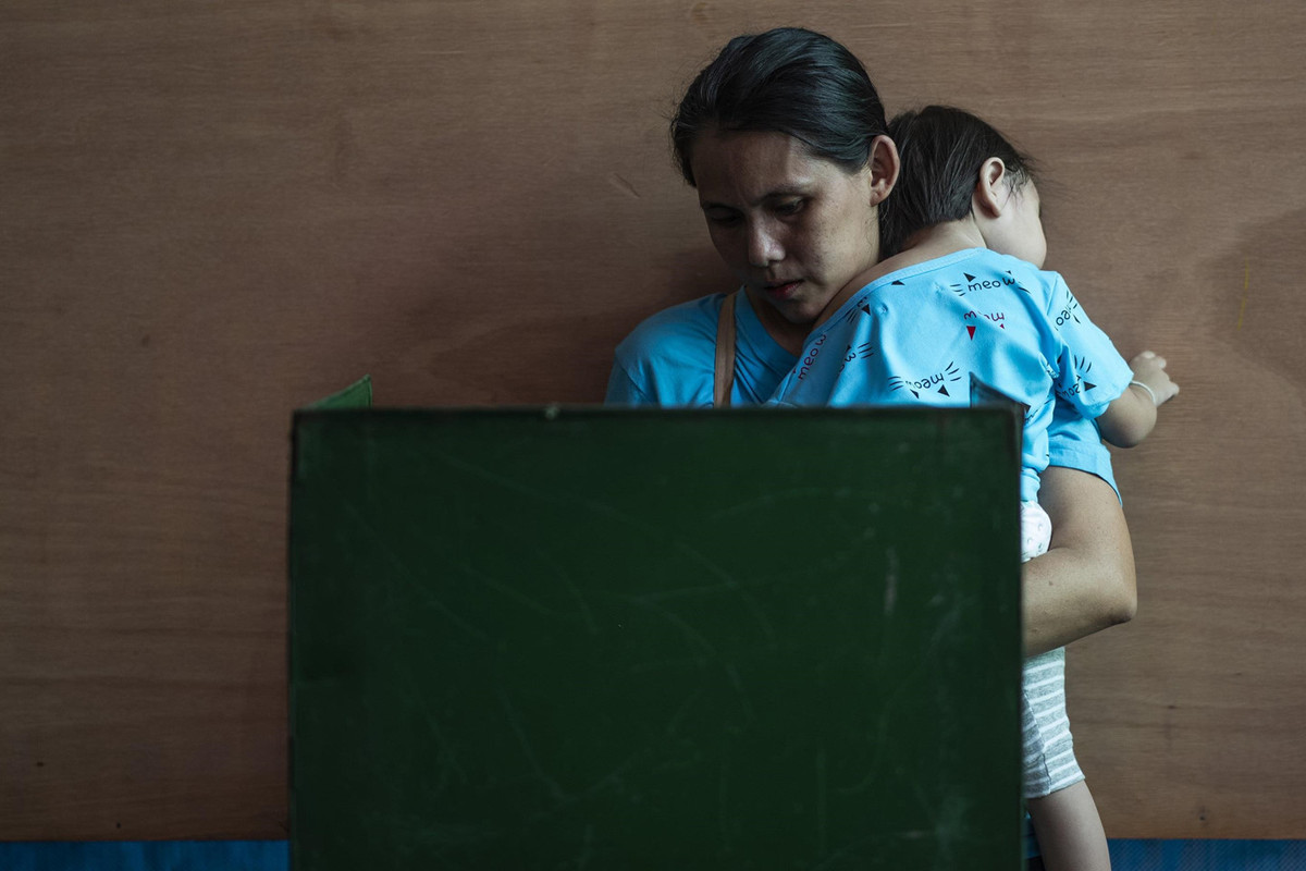 Một em nhỏ được mẹ đưa đi cùng tham gia bỏ phiếu tại Bangkok. Ảnh: AFP.