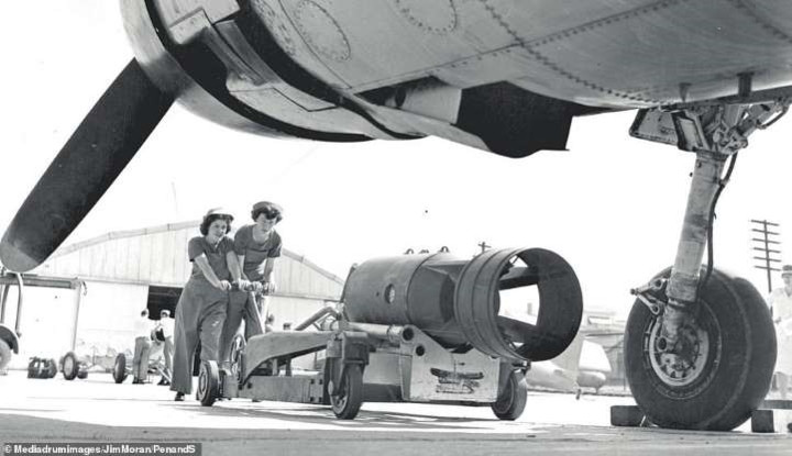 Hai thành viên của một đơn vị lính dự bị đang chuyển vũ khí vào trong máy bay.