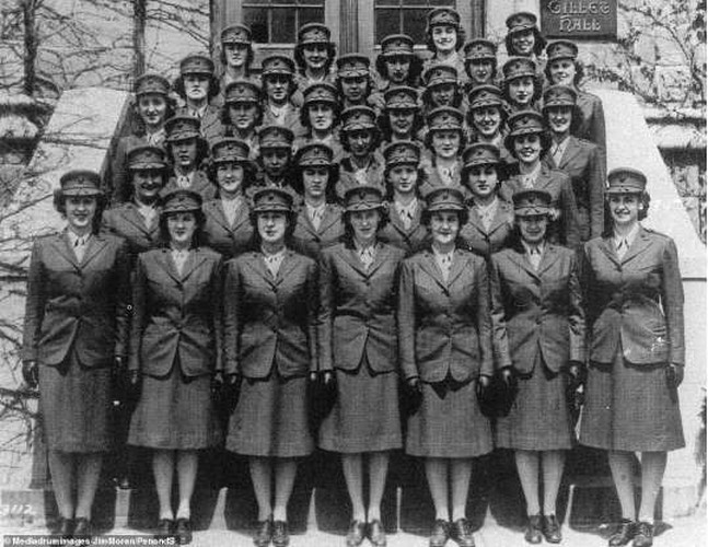 Một nhóm nữ thủy quân lục chiến Mỹ trong bộ đồng phục màu xanh lá với váy dài quá gối, áo vest và mũ.