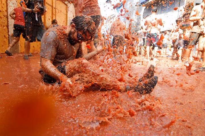 Một người tham gia lễ hội "tắm" trong cơn mưa cà chua tại lễ hội Tomatina ở Bunol, Tây Ban Nha ngày 29/8.
