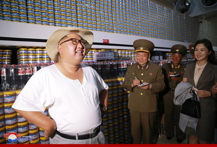 Tháp tùng ông Kim trong chuyến thăm nhà máy có Phu nhân Ri Sol Ju (bìa phải).