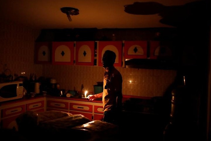 Ông Americo Fernandez phải sử dụng nến để thắp sáng bếp nhà mình khi xảy ra mất điện tại thành phố Maracaibo, Venezuela, vào ngày 25/7.