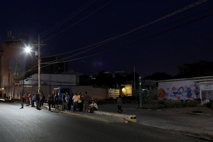 Người dân đợi xe bus ở Maracaibo vào ngày 26/7. Thành phố này từng nổi tiếng với các cuộc tiệc tùng thâu đêm. Nay nơi đây về đêm thường chìm trong bóng tối mịt mùng.