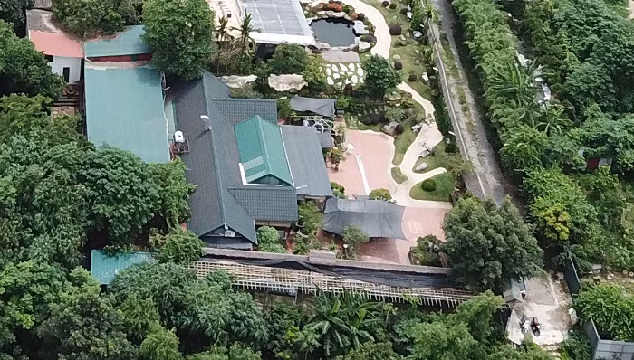 Lối di chuyển vào công trình này là một con đường bê tông được đổ rộng và dài. Xung quanh công trình là hệ thống tường rào cao trên 2m bao bọc nhằm tránh sự quan sát của người bên ngoài. Do lấn chiếm, xây trên đất bãi bồi sông Hồng nên công trình còn dựng hệ thống bờ kè kiên cố.