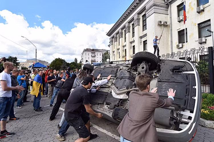 Đêm 15/6/2014, các phần tử cực đoan Ukraine đã chặn lối vào Đại sứ quán Nga ở Kiev, ném bom xăng vào tòa nhà, lật nhào, đập phá xe của các nhà ngoại giao Nga. Ảnh Sputnik