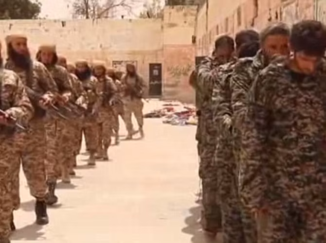 Đám phiến quân IS lớn tuổi dẫn các binh sĩ Syria vào địa điểm hành quyết.