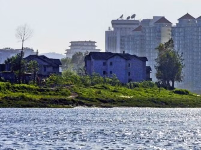 Các tòa nhà cao tầng của thành phố Đan Đông (Trung Quốc) khiến nhà cửa của thành phố Sinuiji của Triều Tiên trông càng trở nên lụp xụp.