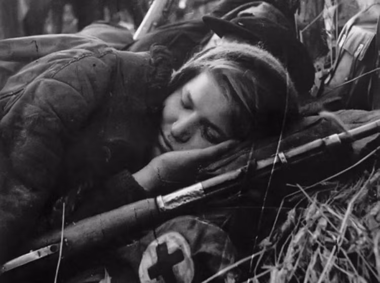 Túi cứu thương và khẩu súng là vật bất ly thân của nữ ý tá đang nghỉ ngơi sau trận đánh ác liệt.