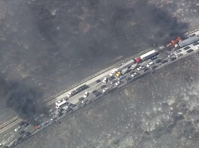 Bức ảnh chụp từ trên cao vụ cháy xe trên đường cao tốc 15 khiến cho nhiều người bị thương. Lực lượng cứu hỏa đã rất vất vả chiến đấu với giặc lửa.