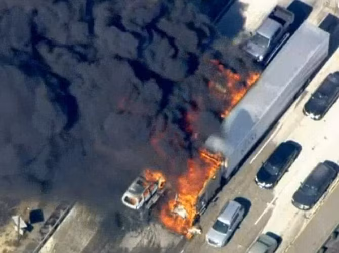 Các xe khác cố gắng chạy xa chiếc xe tải đang bốc cháy ngùn ngụt.