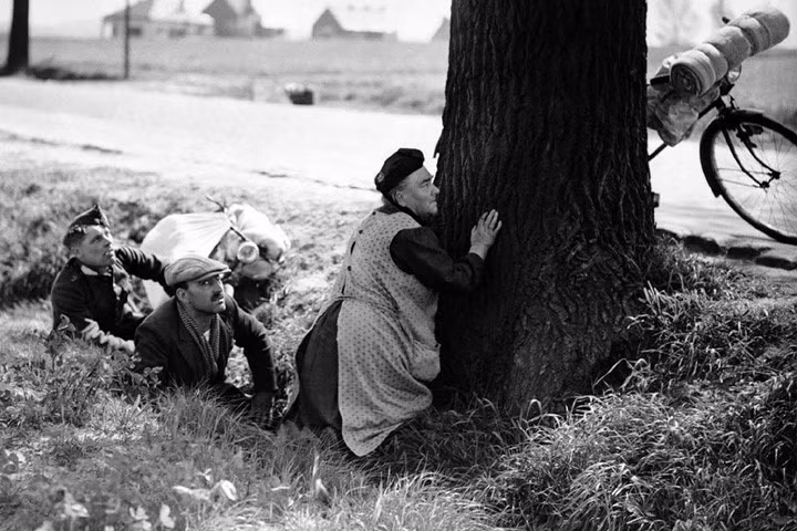 Một người phụ nữ đi sơ tán với một ít hành lý mang theo. Bà nấp sau một cây ven đường khi máy bay Đức không kích khu vực này (thuộc nước Bỉ) vào ngày 18/5/1940. Ảnh: Bộ Quốc phòng Đức