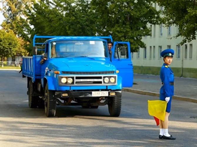 Nữ cảnh sát giao thông điều khiển xe cộ đi lại trên đường phố.