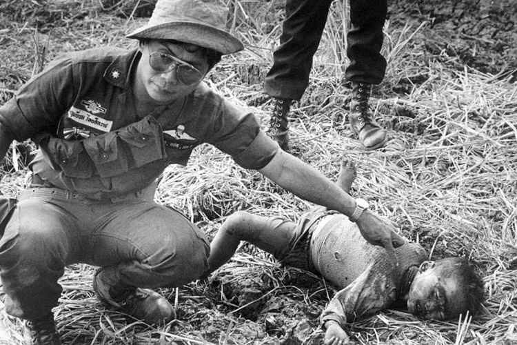 Một sĩ quan biên phòng Thái Lan khám nghiệm tử thi một bé trai Campuchia bị Khmer Đỏ sát hại. Thailand, 1977. Ảnh: Getty Images