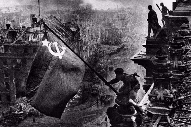 Nhiếp ảnh gia Khaldei ghi lại lịch sử bằng những bức ảnh để đời. Trong ảnh là chiến sĩ Hồng quân Liên Xô phất cờ chiến thắng trên nóc tòa nhà Quốc hội Đức ở thủ đô Berlin năm 1945. Ảnh: russiainphoto.ru © russiainphoto.ru Khaldei made his first camera out of cardboard boxes, creating a lens from a pair of old glasses. He was 13. When the teen, whose mother and grandfather were killed during the Jewish pogrom in Ukraine in 1918, began working at a local plant, he bought himself a decent camera and published his first amateur photographs in a local newspaper.