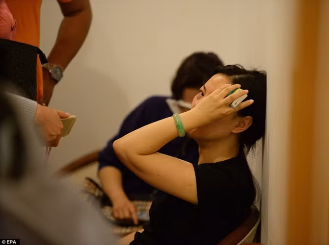 Một phụ nữ than khóc khi biết tin con tàu chở bố mẹ cô bị lật chìm.