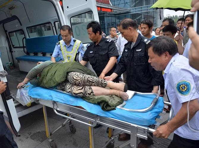 Một phụ nữ được đưa lên xe cứu thương, sau khi được nhân viên cứu hộ lôi khỏi còn tàu bị lật úp trên sông Dương Tử.