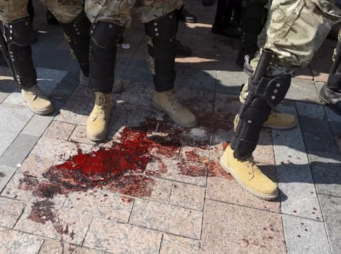 Bộ trưởng Bộ Nội vụ Ukraine, ông Arsen Avakov, thông báo rằng một binh sĩ của Lực lượng Vệ binh Quốc gia đã thiệt mạng sau khi bị đạn bắn trúng tim trong cuộc bạo loạn bùng nổ trước tòa nhà Quốc hội Ukraine. Trong ảnh: Một vũng máu trước trụ sở Quốc hội Ukraine.