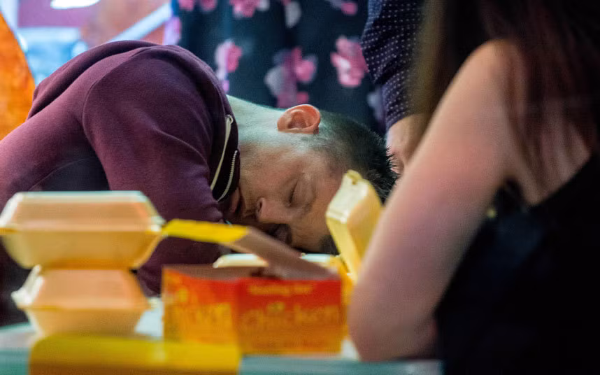 Một chàng trai ngủ vùi trên bàn ở Wind Street, thành phố Swansea.