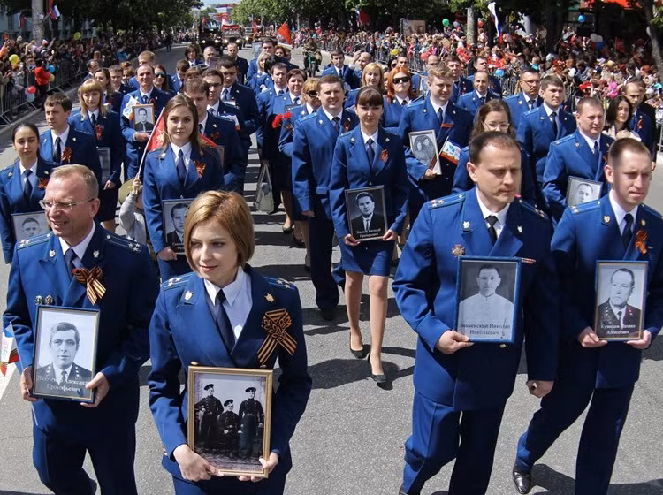 Hàng ngàn người diễu hành "Trung đoàn Bất tử" trên Bán đảo Crimea. Trong ảnh: Nữ Tổng công tố xinh đẹp Natalia Poklonskaya cầm ảnh đi đầu đoàn diễu hành trong Ngày Chiến thắng phát xít Đức 9/5/2015.