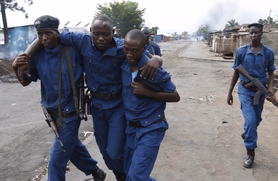 Những người biểu tình đã dùng gạch đá chống trả cảnh sát. Trong ảnh: Hai cảnh sát dìu một đồng đội bị thương.