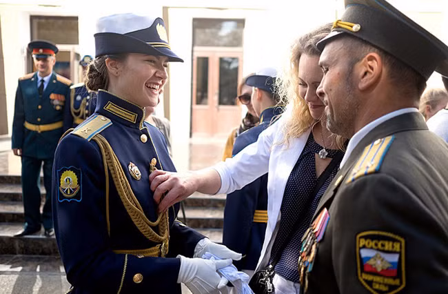 Người mẹ sửa sang trang phục cho nữ học viên phi công quân sự. Ảnh: Russia Beyond