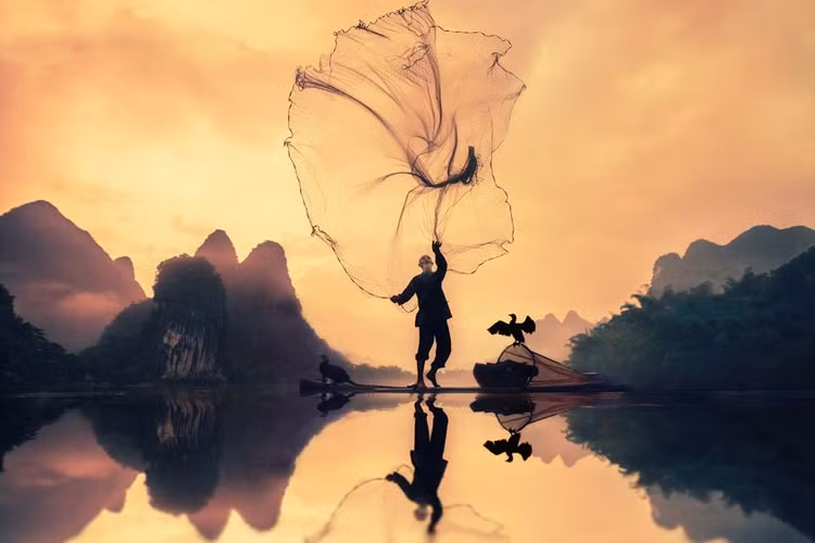 Lão ngư Trung Quốc quăng chài bắt cá trên sông, với sự trợ giúp đắc lực của hai chú bồ nông.Đây là 1 trong 200.000 ảnh dự giải Sony Awards 2017. Ảnh: Daily Mail