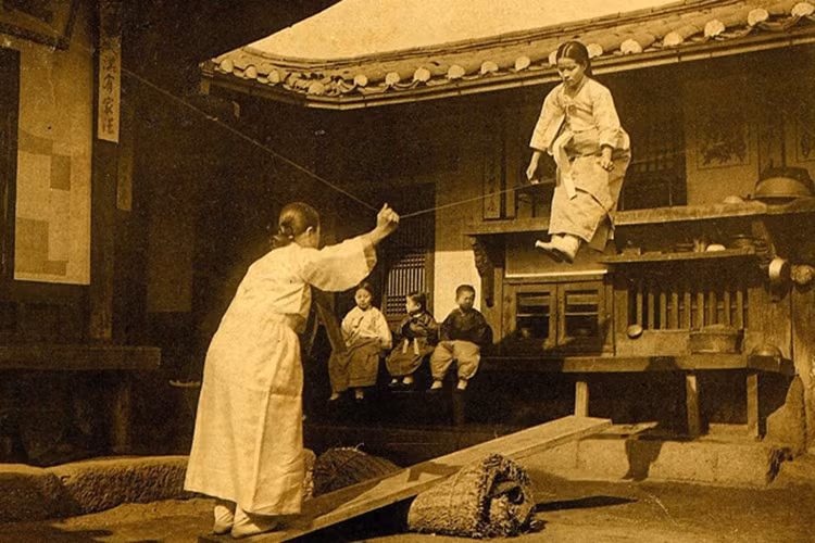 Các cô gái trẻ chơi trò bập bênh Neolttwigi trong bức ảnh được chụp trong thời gian 1900-1905. (Nguồn: Daily Mail)