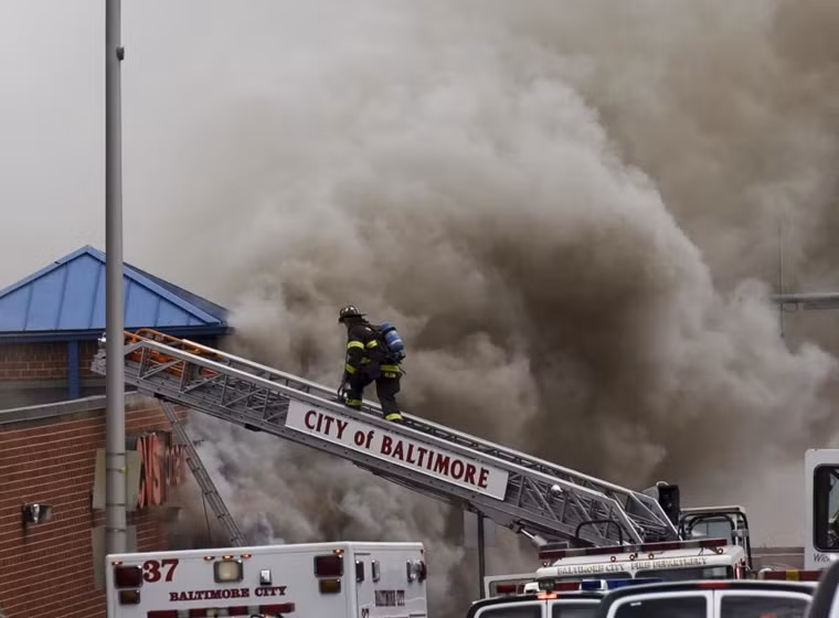 Nhiều cửa hàng bị đốt cháy. Trong ảnh: Lính cứu hỏa đang cố dập tắt một đám cháy ở Baltimore.