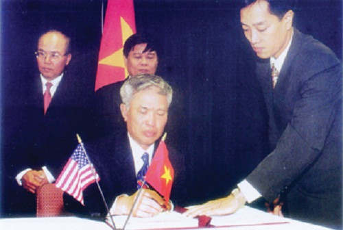  9. Năm 2000, hai nước ký Hiệp định Thương mại song phương Chưa đầy một năm sau ngày hai nước bình thường hóa quan hệ, tháng 5/1996, Mỹ chủ động gửi Việt Nam Dự thảo Hiệp định Thương mại song phương Việt - Mỹ. Sau hơn 4 năm đàm phán và thông qua các thủ tục pháp lý, ngày 13/7/2000, tại Washington, BTA đã được ký kết và có hiệu lực kể từ ngày 10/12/2001. Đây là hình ảnh ông Vũ Khoan ký Hiệp định Thương mại song phương với Hoa Kỳ (BTA), tháng 7/2000.