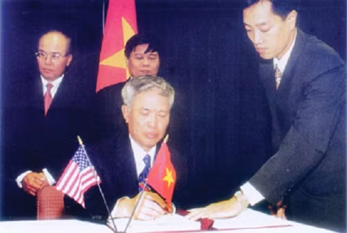  9. Năm 2000, hai nước ký Hiệp định Thương mại song phương Chưa đầy một năm sau ngày hai nước bình thường hóa quan hệ, tháng 5/1996, Mỹ chủ động gửi Việt Nam Dự thảo Hiệp định Thương mại song phương Việt - Mỹ. Sau hơn 4 năm đàm phán và thông qua các thủ tục pháp lý, ngày 13/7/2000, tại Washington, BTA đã được ký kết và có hiệu lực kể từ ngày 10/12/2001. Đây là hình ảnh ông Vũ Khoan ký Hiệp định Thương mại song phương với Hoa Kỳ (BTA), tháng 7/2000.