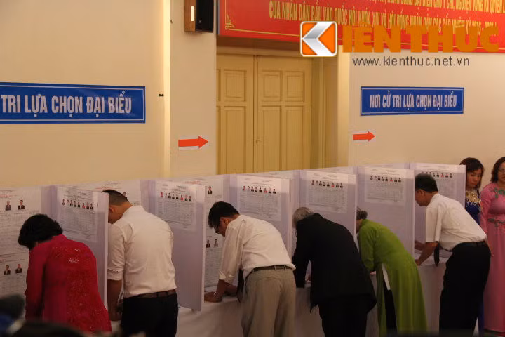 Tổng bí thư Nguyễn Phú Trọng cùng một số bà con nhân dân tham gia viết phiếu lựa chọn cử tri.