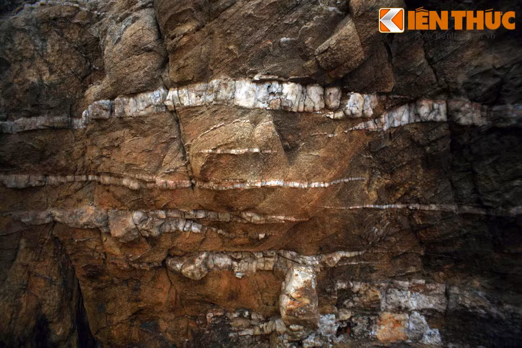 Giữa bề mặt đá màu nâu trầm, các sọc trắng tinh hiện ra theo thớ dọc, ngang, trông xa tưởng như có ai nghịch ngợm dùng vôi trắng quét lên.