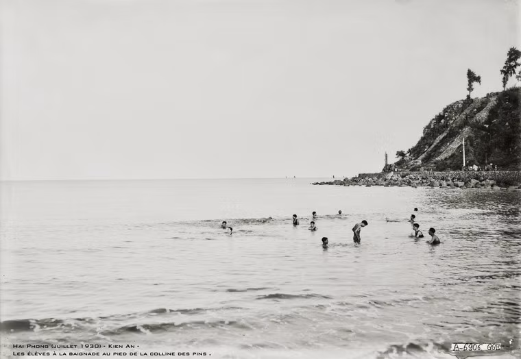 Các học sinh tắm biển dưới chân một ngọn đồi ở Hải Phòng.