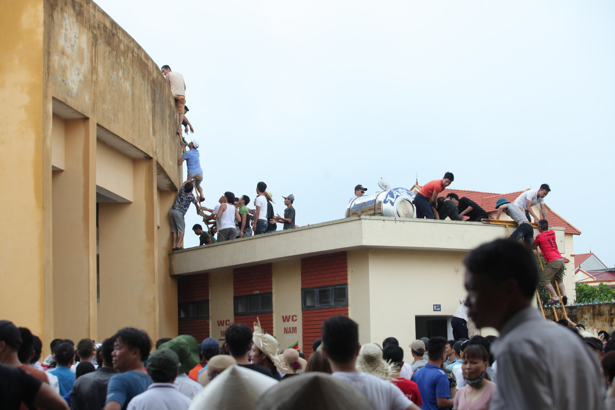 Để vào được sân, nhiều người phải leo trèo như thế này.