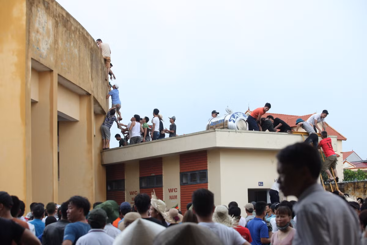 Để vào được sân, nhiều người phải leo trèo như thế này.