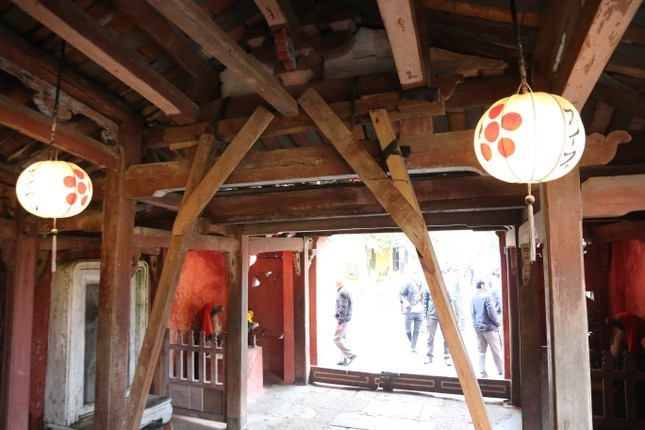 Do xuống cấp, lực lượng chức năng gia cố Chùa Cầu bằng những thanh gỗ. (Ảnh: Tiền Phong).