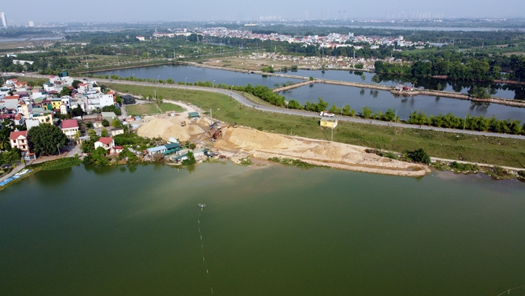 Quan sát từ trên cao thấy rõ, nước màu xanh ở trong ao dần bị hòa lẫn với các màu lạ, chảy xuống từ khu máy sàng đất của bãi tập kết.