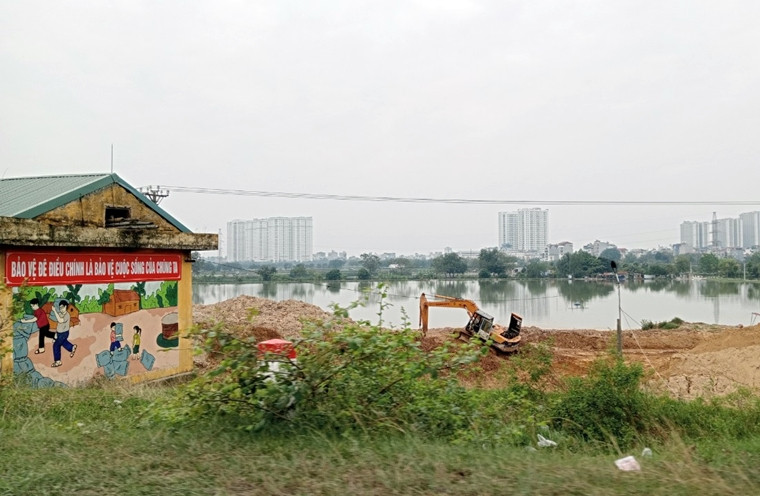 Những bảng biển "bảo vệ đê điều..." được treo rất lớn, rất rõ ngay gần với bãi tập kết.