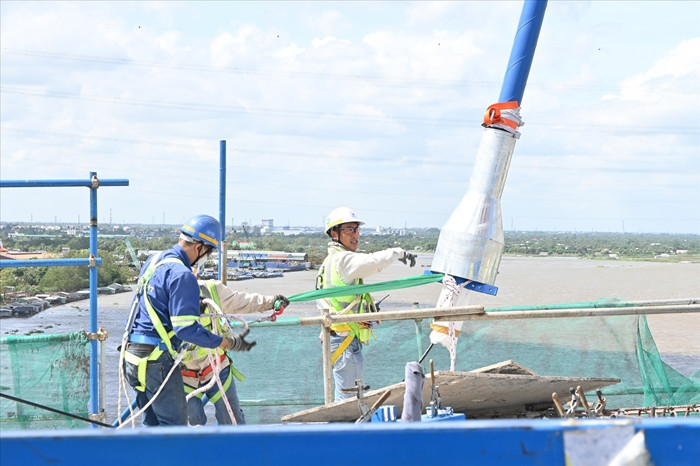 Căng dây cáp đầu tiên tại tháp trụ T16 dự án công trình cầu Mỹ Thuận 2 vào trưa ngày 5/12. (Ảnh: Báo Lao Động).