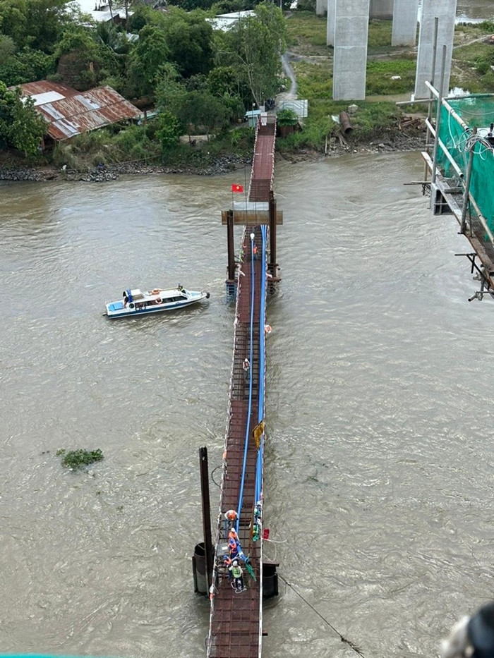 Công nhân đang kéo cáp dây văng. (Ảnh: Pháp luật TP.HCM).