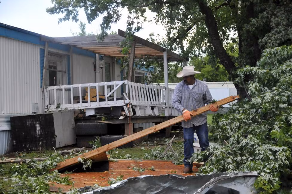 Còn đây là Jesus Morelos, người đàn ông này đang dọn dẹp các mảnh vỡ sau khi cơn lốc xoáy đáp xuống và phá hủy gần như toàn bộ ngôi nhà và sân vườn ở Apollo Mobile Home Park, Oklahoma.