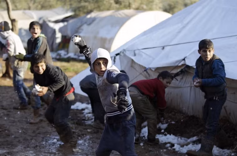 Những đứa trẻ chơi đùa với tuyết tại khu vực trại tị nạn Atma giáp biên giới Syria-Thổ Nhĩ Kỳ phía bắc thành phố Idlib, Syria ngày 11/1/2015. 