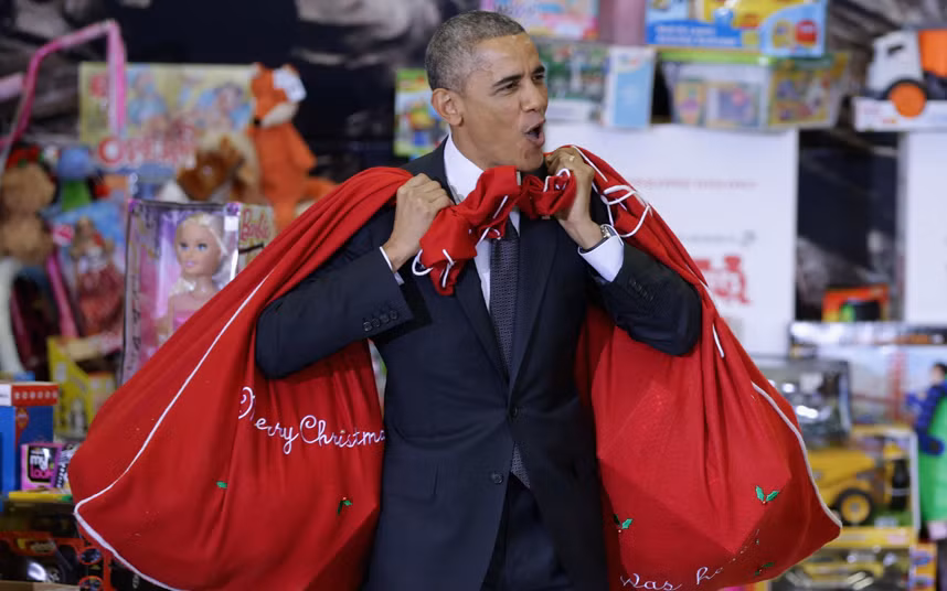 Ông chủ Nhà Trắng hào hứng vác trên vai hai túi đựng đầy quà và đồ chơi cho các em nhỏ ngày lễ Giáng sinh.