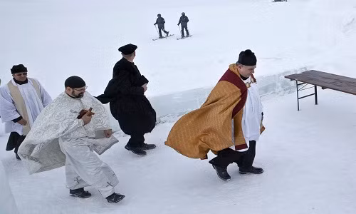 Các vị linh mục người Romania đang trên đường đến nhà thờ được xây từ các tảng băng ở trên núi Fagaras vào ngày 29/1.